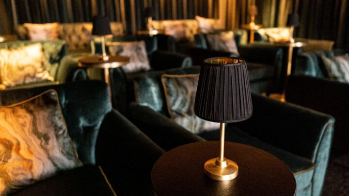 Luxurious velvet seating with warm ambient lighting in an elegant hotel lounge, perfect for relaxation and comfort.