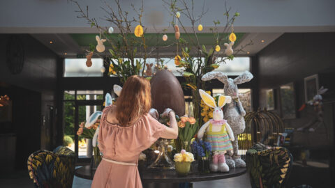 Hotel lobby with Easter decorations, plush bunnies, and floral arrangements, creating a festive and welcoming atmosphere.