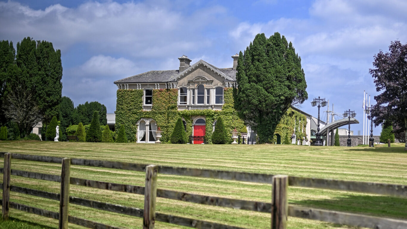 Serene countryside hotel with ivy-clad facade, lush gardens, and spacious grounds perfect for a relaxing getaway.
